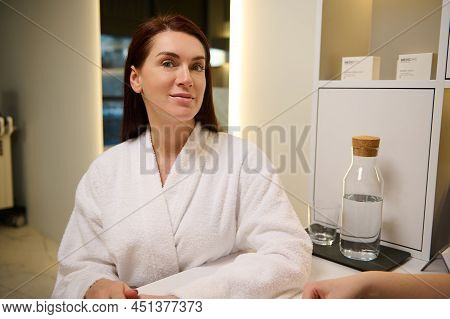 Attractive Caucasian Middle Aged Woman In White Terry Bathrobe At Medical Appointment In Cosmetologi