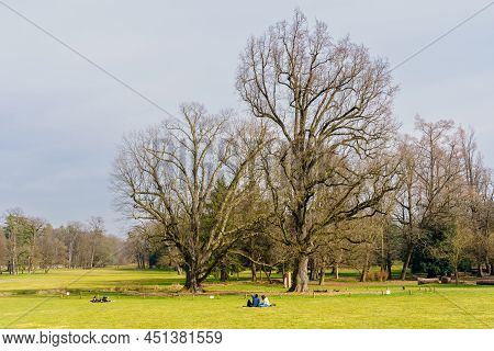 Monza, Italy - February 24, 2022: View Of Lawn, Trees, And Visitors In The Monza Park, On A Clear Wi