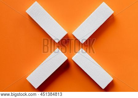Top View Of White Tetragonal Blocks On Bright Orange Background.