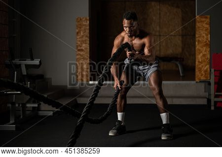Attractive African American Man With Naked Torso Doing Endurance Exercises With Trope.