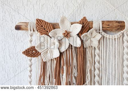 Handmade Macrame Wallhanging. 100% Cotton Wall Decoration With Wooden Stick Hanging On A White Wall.