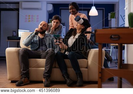 Office Colleagues Using Vr Headset And Joystick To Play Videogames At Party After Work. Man And Wome
