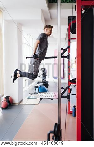 Athlete Man In The Gym Doing Elevations. Caucasian Male Training In The Gym During The Day