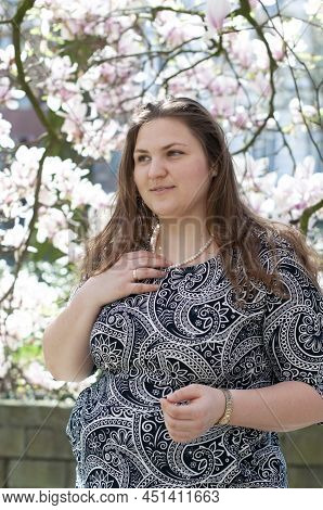 Portrait Of A Beautiful Plump Caucasian Confident Woman In Magnolia Flowers