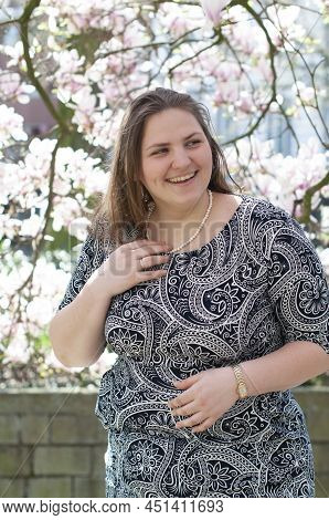 Portrait Of A Beautiful Plump Caucasian Confident Woman In Magnolia Flowers