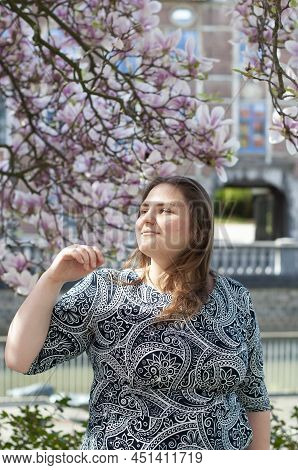 Portrait Of A Beautiful Plump Caucasian Confident Woman In Magnolia Flowers
