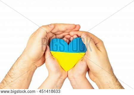 Children's And Man's Palms Hold A Heart In The Colors Of The Ukrainian Flag. Stop The War Concept