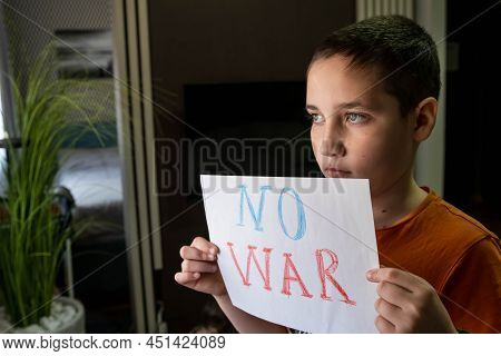 Crying Boy Asks To Stop The War. The Child Holds A Poster. A Child Against War. Antiwar Concept. Fam