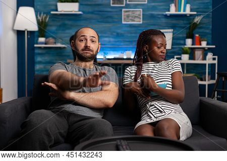 Spooked Young Interracial Couple Watching Together Scary Films On Tv While Sharing A Bowl Of Popcorn