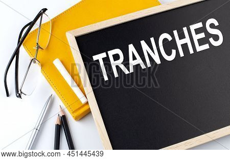 Tranches Text On Blackboard With Notepad , Pen, Pencil