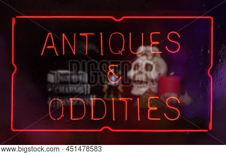 Oddities And Antiques Neon Sign In Rainy Shop Window