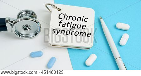 Medical Concept. On A White And Blue Surface Are Pills, A Stethoscope, A Pen And A Notepad With The 