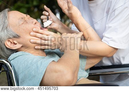 Force-feeding Because Asian Senior Woman Refuses,does Not Want To Eat Food,angry Female Caregiver Sc