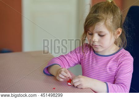 Little Creative Toddler Girl Playing With Small Plastic Blocks. Active Child Having Fun With Creatin