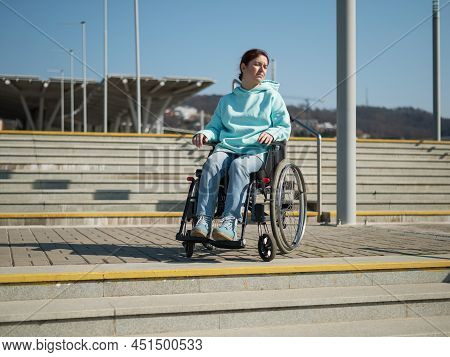 A Caucasian Woman In A Wheelchair Cannot Go Down Stairs Without A Ramp. Hard To Access Environment.