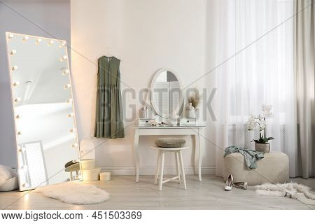 Large Mirror With Light Bulbs And Dressing Table In Stylish Room. Interior Design