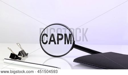 Capm Text Concept. Magnifier Glass With Text , Notebook And Pen