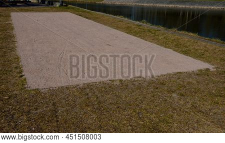 Petanque Field Of White, Yellow Sand In A Park Among The Bushes Game With Metal Balls Common In Fran