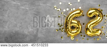 Yellow Foil Balloon Number, Number Sixty Two On A Concrete Background. Greeting Card With The Inscri