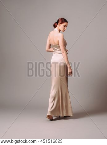 Elegant Backless Moscato Dress. Beautiful Ivory Silk Evening Gown. Studio Portrait Of Young Ginger W