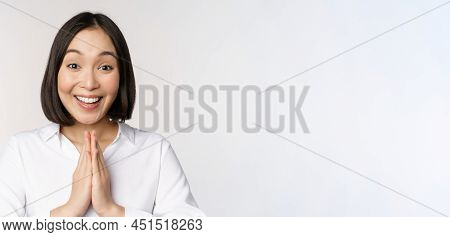 Close Up Portrait Of Young Japanese Woman Showing Namaste, Thank You Arigatou Gesture, Standing Over