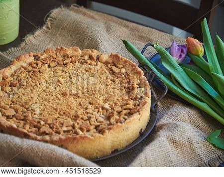 Homemade Delicious Pie With Cookie Crumbs And Delicate Tulips On The Table. Food Background.