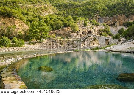 Benja Thermal Baths in Permet, Albania. Pool with hot water and old arch shape stone bridge at background. Popular tourist destination in Albania
