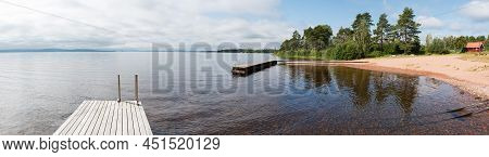 Woman Standing On A Rectanguar Shaped Pier At The Ljusnan River, Segersta, Halsingland, Sweden