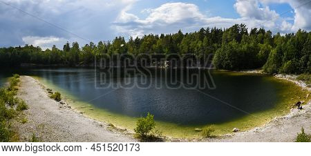 Panoramic Landscape View Over The Small Lake And Natural Surroundigs With A Beach And Woods Around T