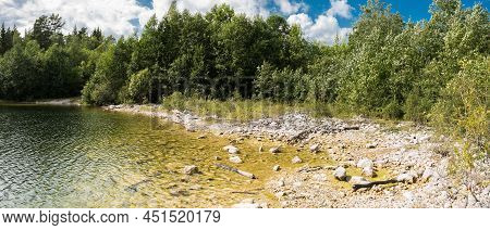 Panoramic Landscape View Over The Small Lake And Natural Surroundigs With A Beach And Woods Around T