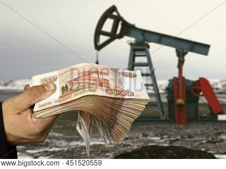 The Shadow Of The Oil Rig Against The Background Of Russian Money. Concept Of Selling Minerals For R