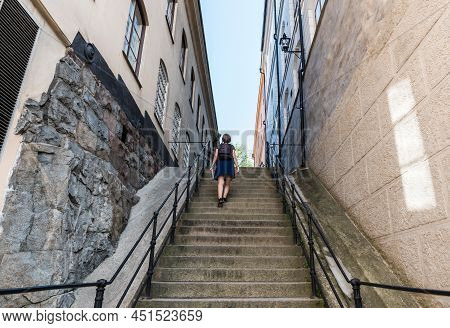 Stockholm, Sweden - 07 24 2019- Attractive Tourist Woman In Summer Skirt Walking Up A Stair In Gamla