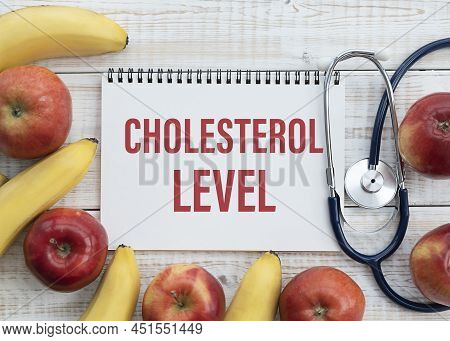 Cholesterol Level Text On Paper With Stethoscope, Delicious Red Apple, Measurement Tape And Blue Dum