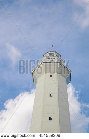 White Lighthouse Against Blue Sky With White Clouds On Rote Island, Indonesia.
