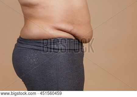 Side View Of Overweighted Female With Flabby Thick Stomach Wearing Leggings. Body Positive. Violatio