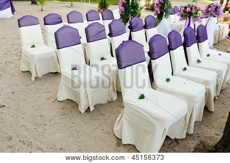 結婚式の椅子 Decoratedd 紫色のリボンで、ビーチに設定します。