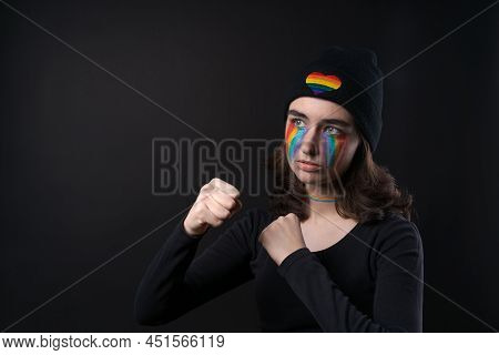 Portrait Young Crying Woman With Painted Lgbt Flag On Her Cheek. Crying With Rainbow In Black Hat Wi