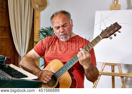 Pensive Mature Man Playing Acustic Guitar And Singing Song At Home. Music Hobby. Creative Leisure. S