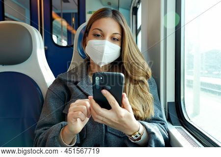 Relaxed Woman With Kn95 Ffp2 Face Mask Using Smart Phone App. Train Passenger With Protective Mask T