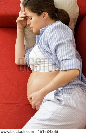 Young And Pregnant Woman At Home Feels Sick