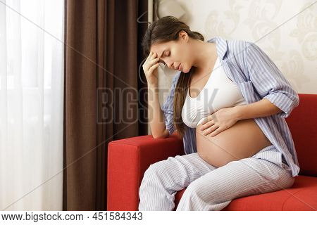 Young And Pregnant Woman At Home Feels Sick