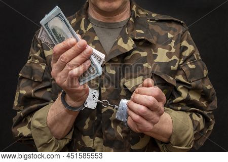 A Military Soldier Or Officer In Handcuffs Holds Bundles Of Dollar Bills In His Hands, Selective Foc