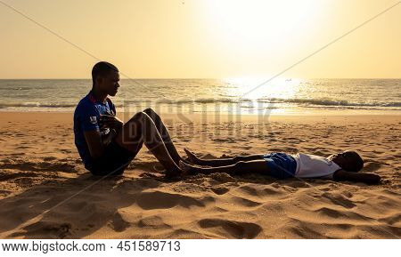 Saly, Mbour, Senegal - Circa December 2021. Unidentified Mature Man And Teenager, Father And Son, Do