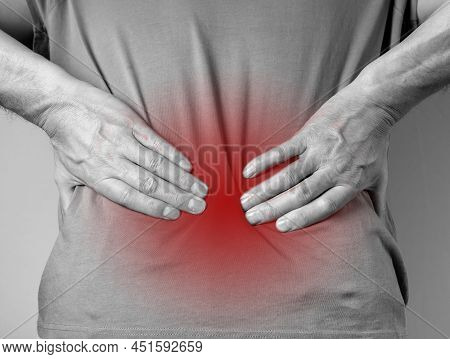 Lower Back Pain. Man Hands Holding Red Painful Spot Closeup. Sedentary Lifestyle, Injury, Chronical 