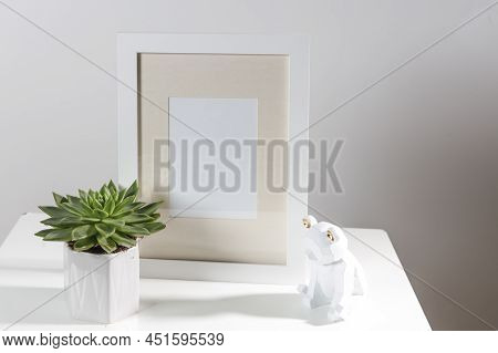 Echeveria In A Geometric Pot Next To A Photo Frame And A Wooden Bear Figurine. Layout. Place For Tex