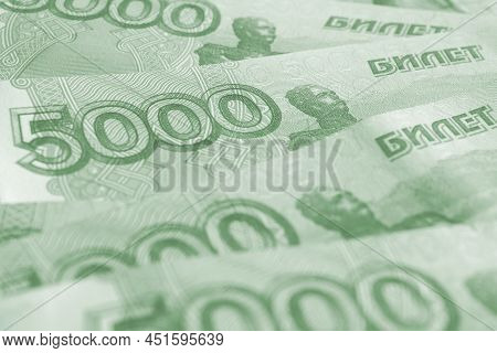 Several Russian Banknotes Of 5000 Rubles Close-up. Light Green Tinted Background. Pale Wallpaper Abo