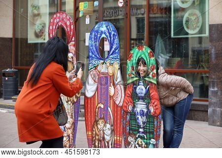 Moscow, Russia - March 2022: Two Happy Women Photograthing With Matryoshka Dolls On Novy Arbat Stree