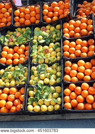 Oranges And Yellow Organic Lemons With Green Leaves For Sale In A Stall At The Vegetable Market