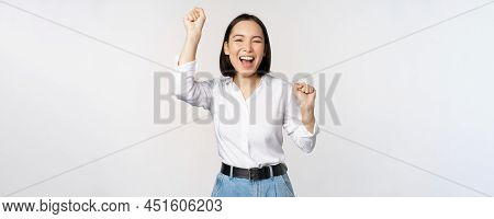 Image Of Happy Lucky Asian Woman Hooray Gesture, Winning And Celebrating, Triumphing, Raising Hadns 