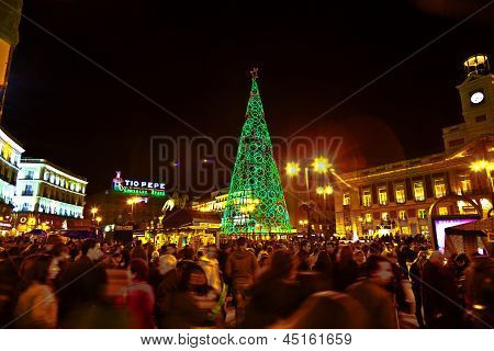 Puerta Del Sol adlı ünlü ışıklı Noel ağacı geçen Noel zamanında eğlenceli insanlar var